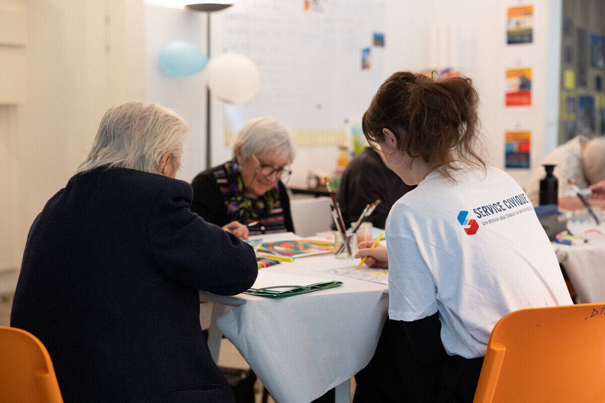 Une volontaire en Service Civique en atelier avec des personnes en situation de handicap.