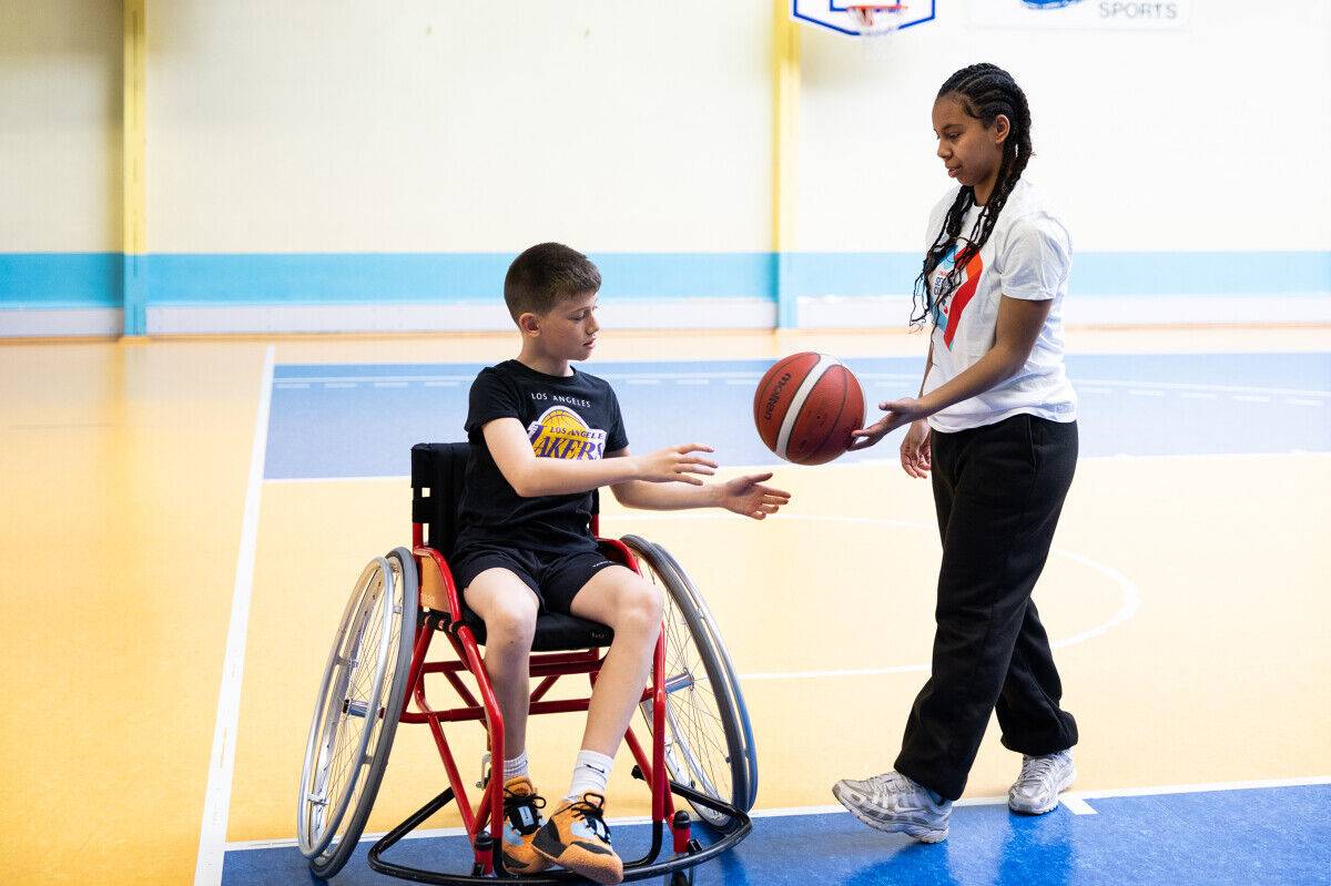 Une volontaire en Service Civique fait de la sensibilisation au basket-fauteuil.