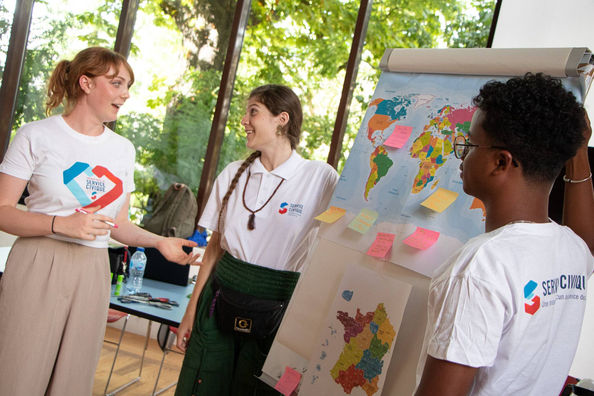Des volontaires en Service Civique devant une map